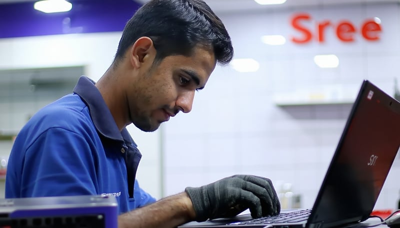 Technician repairing a laptop at Sree Services